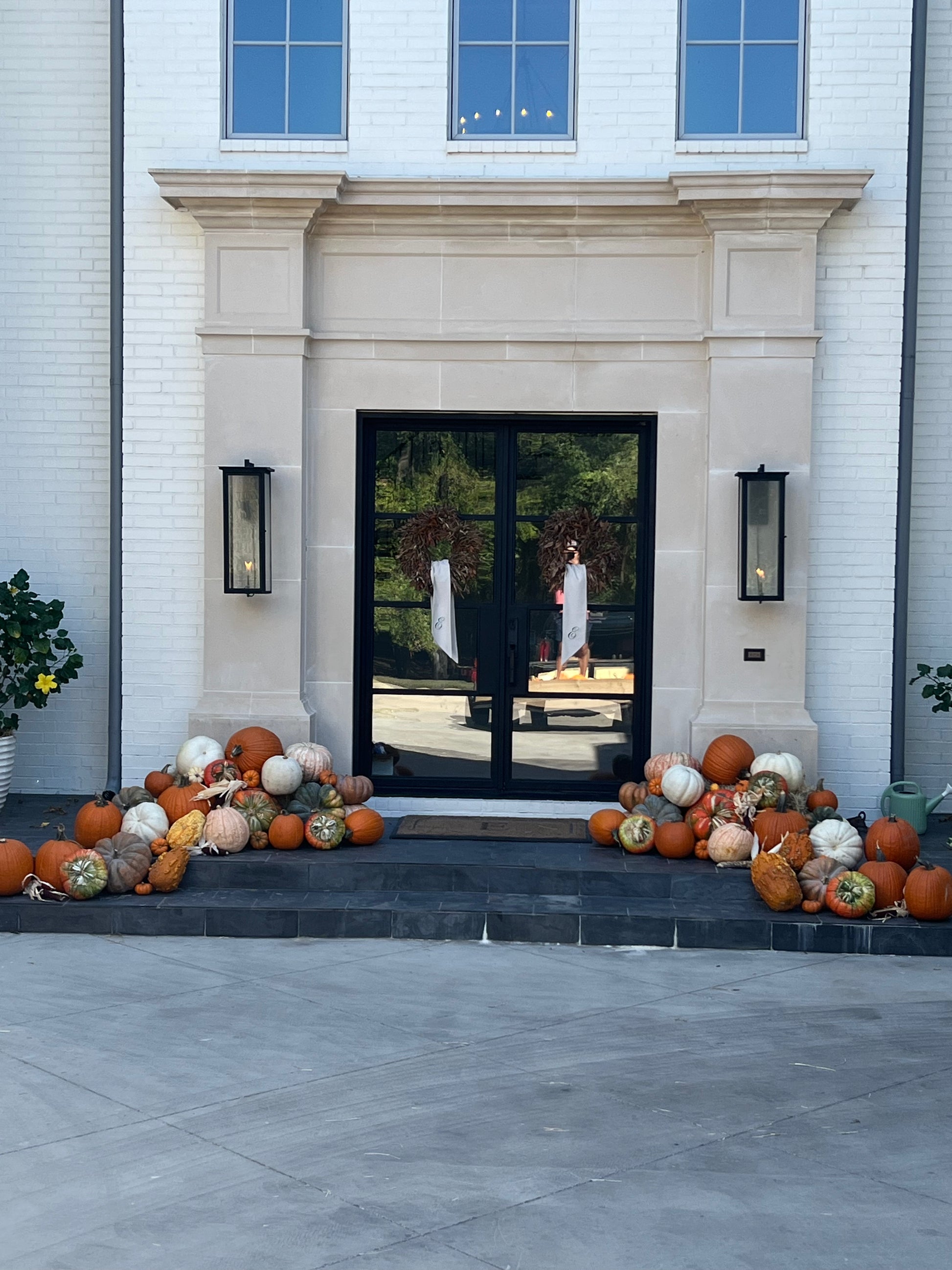 Decorative pumpkins on steps leading to a modern house entrance.